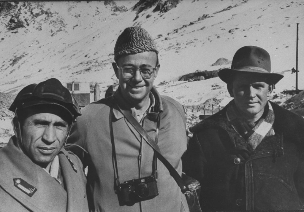 James Burke standing with friends and a camera around his neck. (Photo by James Burke/The LIFE Picture Collection © Meredith Corporation)
