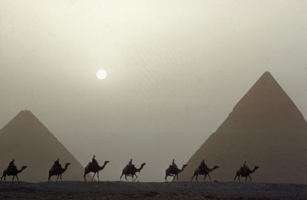 A camel caravan in front of the pyramids of Khefren and Cheops, also called the Great Pyramid. (Photo by Eliot Elisofon/The LIFE Picture Collection © Meredith Corporation)