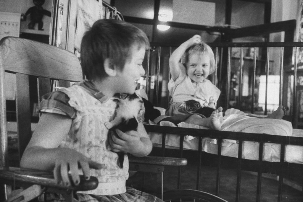Two children play with kittens at the University of Michigan's hospital at Ann Arbor, 1956.