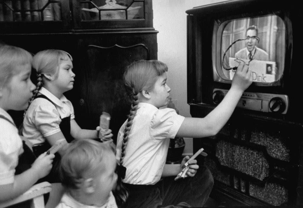 Six-year-old girls use a "Winky Dink" drawing kit on their home TV screen as they watch the kids' program, 1953. The show, which aired for four years in the 1950s, has been cited as "the first interactive TV show," especially in light of its "magic drawing screen"   a piece of plastic that stuck to the TV screen, and on which kids (and, no doubt, some adults) would trace the action on the screen.