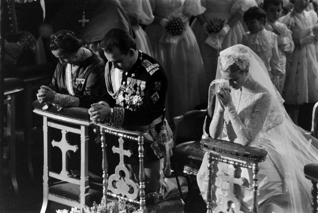 Grace Kelly and Prince Rainier kneel during Mass at their religious wedding, April 1956.