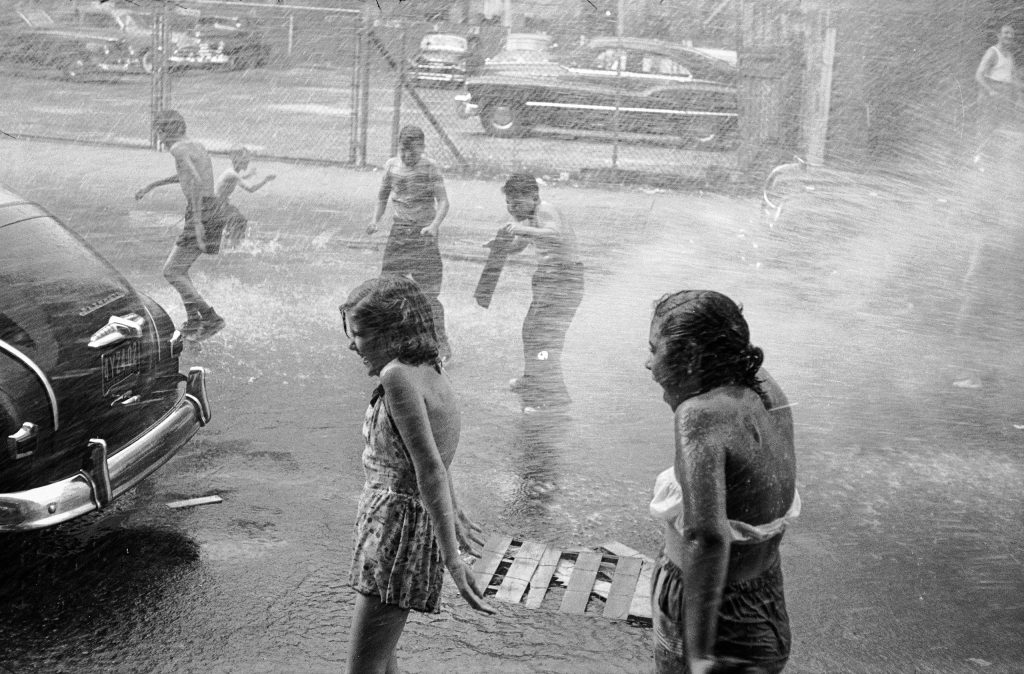 Children playing in water during a heat wave in New York City, 1953.
