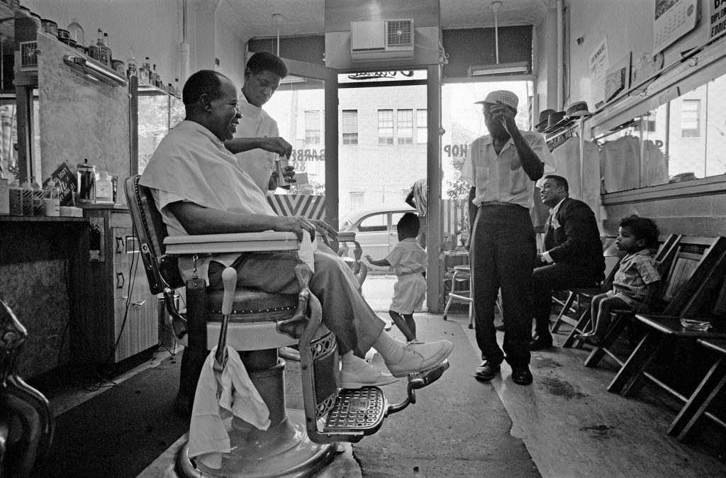 Louis Armstrong at his neighborhood barbershop in Queens, Louis Armstrong gets a beer and a haircut. New York City, 1965.