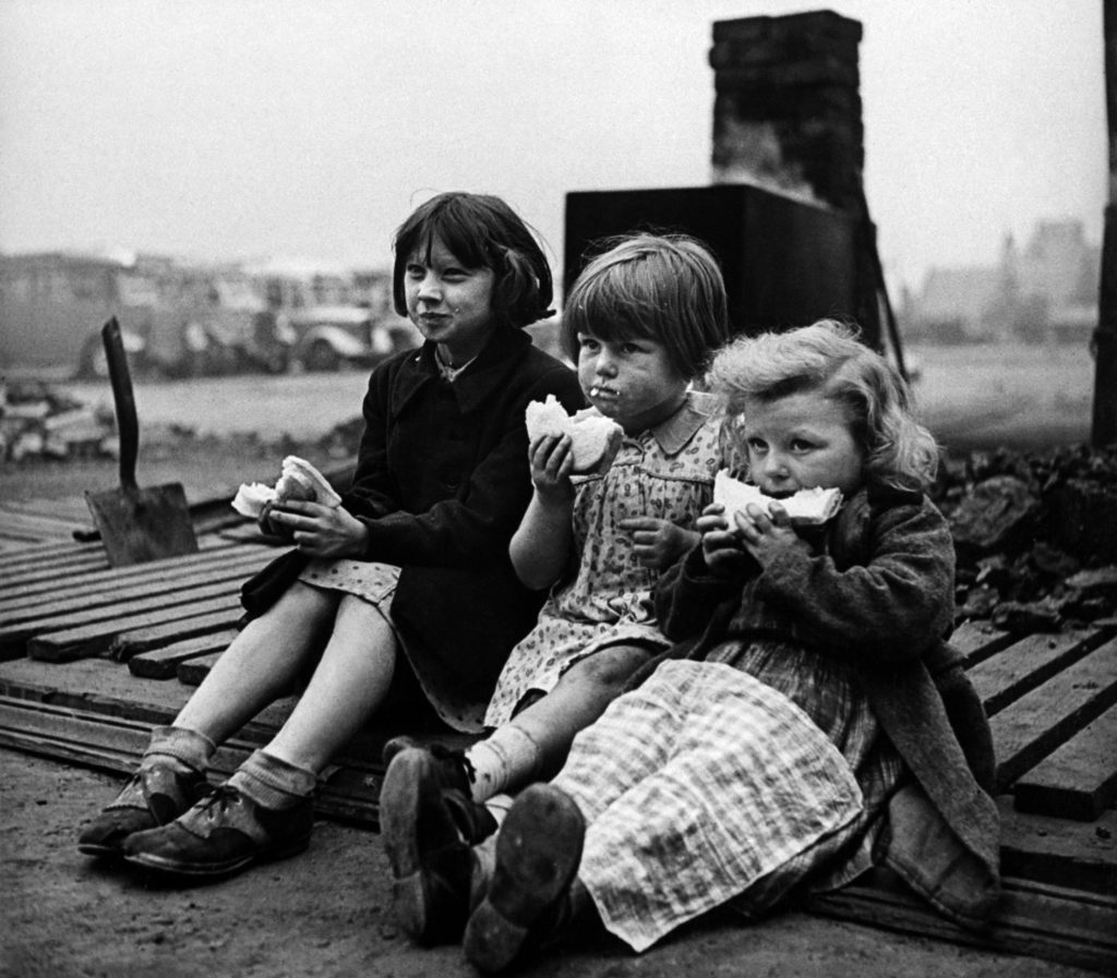 Children in blitzed north of England eating meal from bread and Lease Lend cheese. (Photo by Hans Wild/The LIFE Picture Collection © Meredith Corporation)