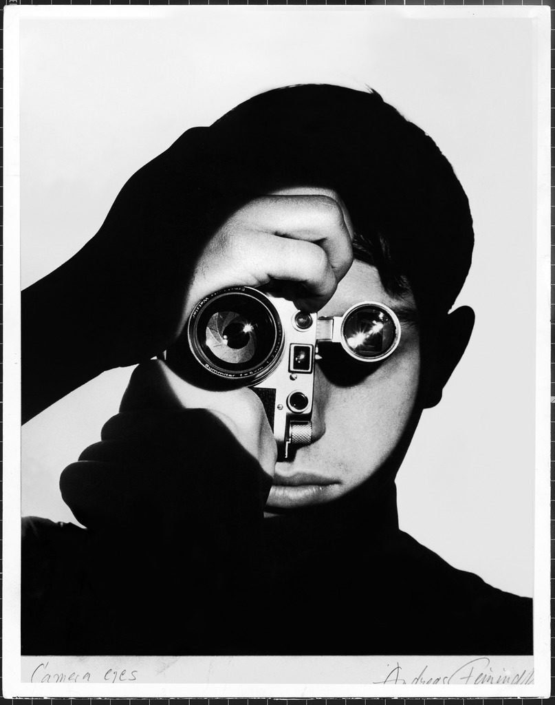 Photographer Dennis Stock holding camera to his face so that the lens looks like his right eye and the viewfinder his left eye. (Photo by Andreas Feininger/The LIFE Picture Collection © Meredith Corporation)