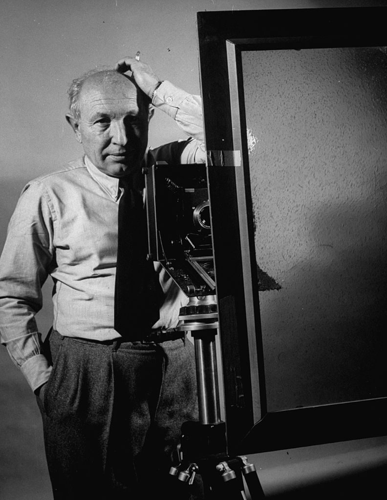 Life photographer, Dmitri Kessel, standing by camera on a tripod, getting ready to shot a picture of himself through a reflection in a make-shift window. (Photo by Frank Scherschel/The LIFE Picture Collection © Meredith Corporation)