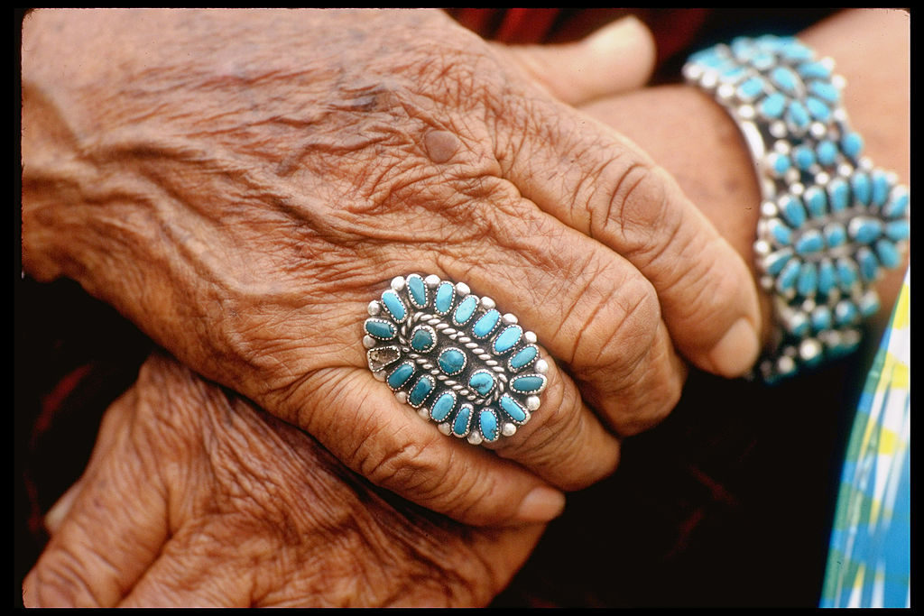Closeup of beautifully weathered hands of Navajo woman modeling turquoise bracelet &amp; ring made by Native Americans. (Photo by Michael Mauney/The LIFE Picture Collection © Meredith Corporation)