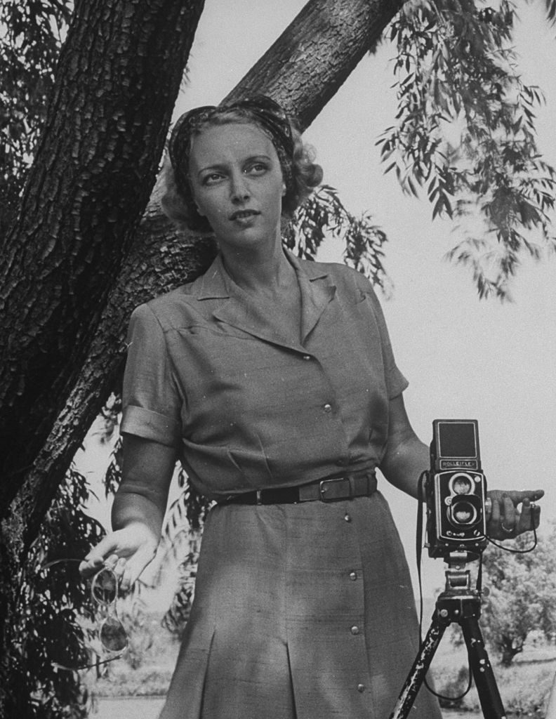 Photographer Nina Leen holding shutter release, standing beside her Rolleiflex, which is set up on tripod. (Photo by Time Life Pictures/Pix Inc./The LIFE Picture Collection © Meredith Corporation)