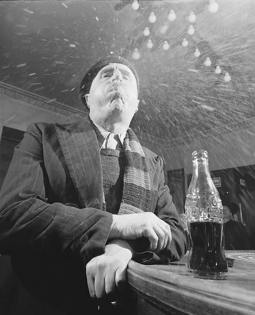 At a bar, a man in a beret spits a mouthful of Coca-Cola at the camera, Paris, France, April 1950. (Photo by Mark Kauffman/The LIFE Picture Collection © Meredith Corporation)