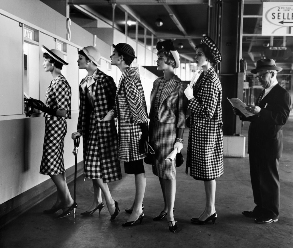 5 models wearing fashionable dress suits at a race track betting window, at Roosevelt Raceway. (Photo by Nina Leen/The LIFE Picture Collection © Meredith Corporation)