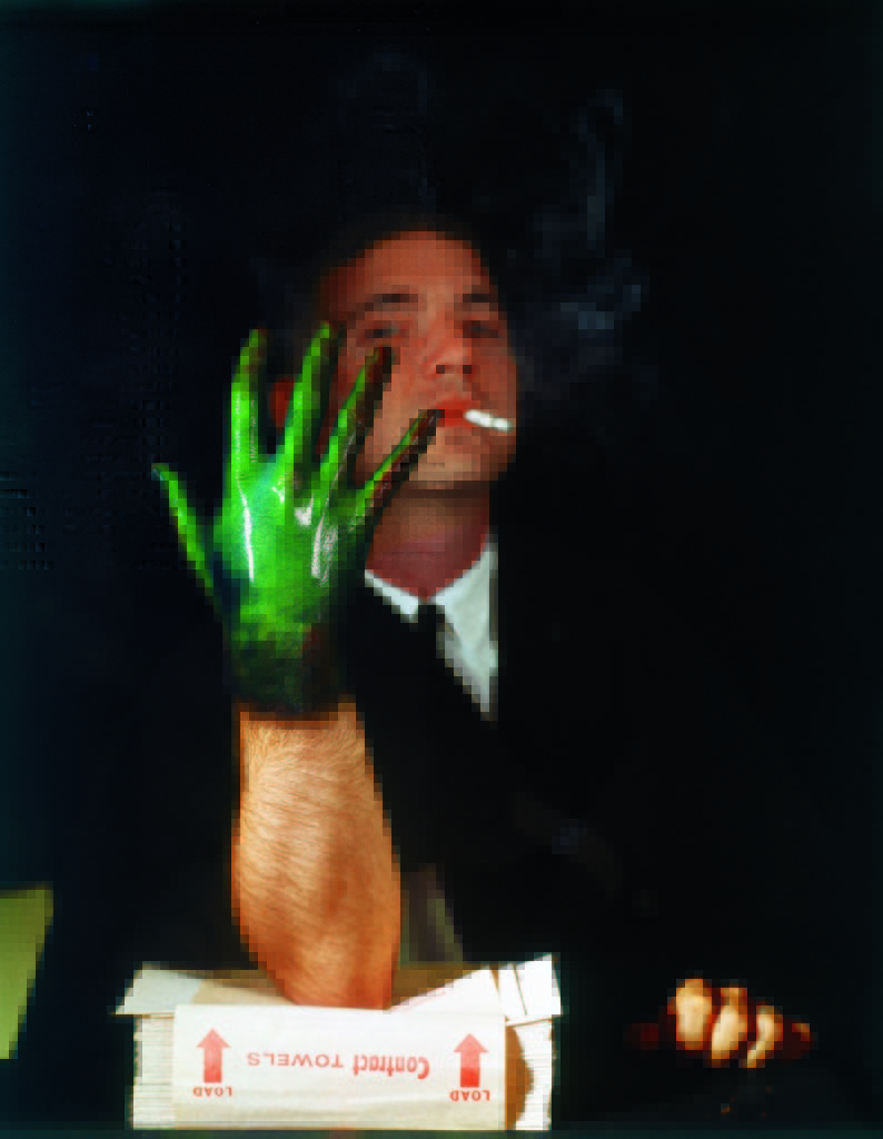 Man displaying his hand, coated with temperature sensitive liquid crystals, revealing decreased blood circulation (green coloration), a result of nicotine in cigarette smoke. (Photo by Henry Groskinsky/The LIFE Picture Collection © Meredith Corporation)