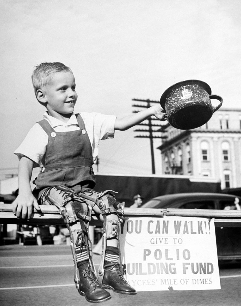 David Henseley, young child crippled by polio with both legs in braces, soliciting funds in public fund-raising driver for a new polio hospital. High Point, N.C., 1948.