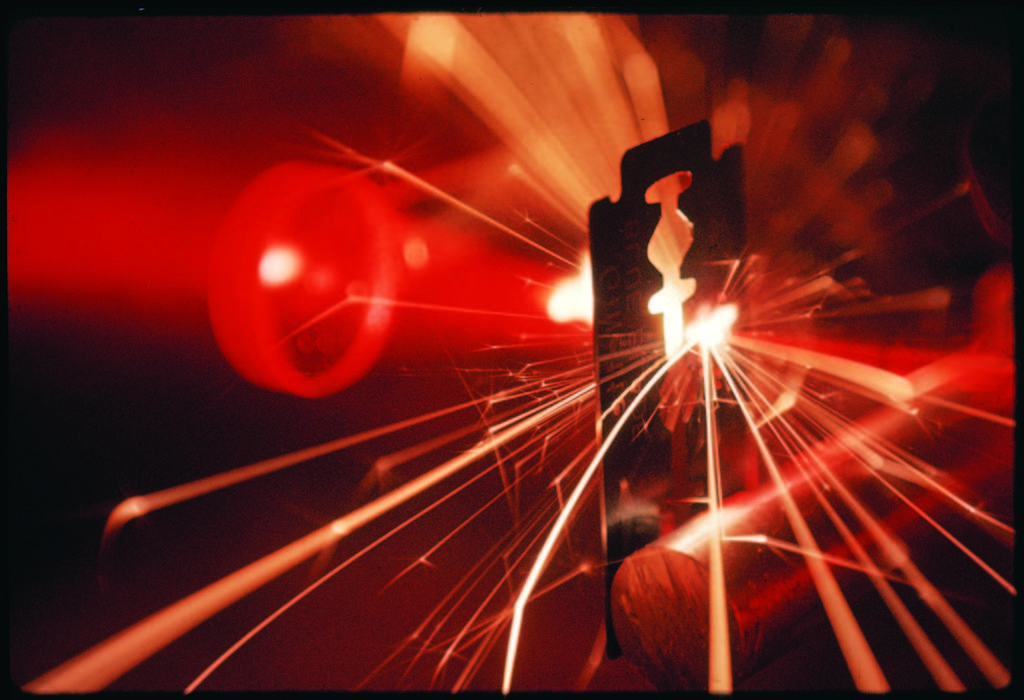 Red laser light focused through a lens blasts a pin-point hole through a razor blade in a thousandth of a second. (Photo by Fritz Goro/The LIFE Picture Collection © Meredith Corporation)