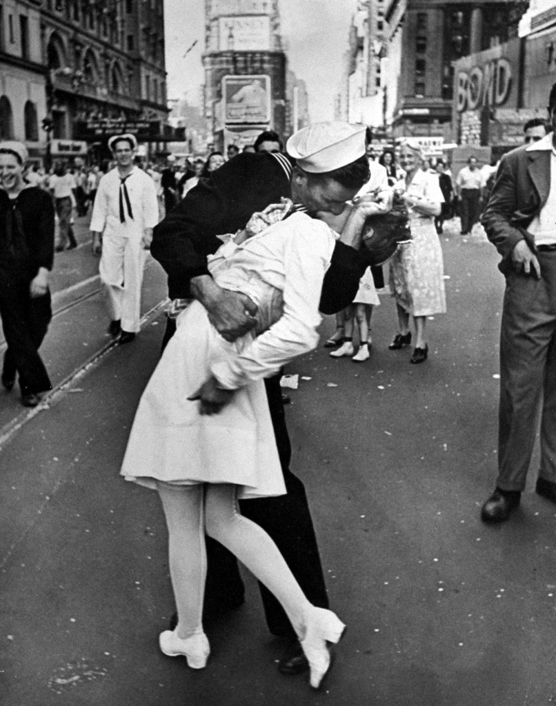 A jubilant American sailor clutched a dental assistant in a back-bending kiss at a moment of spontaneous joy about the long awaited WWII victory over Japan. Taken on V-J Day, 1945, as thousands jammed Times Square. In recent decades this iconic photograph has engendered condemnation, after Greta Zimmer Friedman, the woman being kissed by the sailor (believed to have been George Mendonsa) said that the kiss was nonconsensual. In 2019, shortly after Mendonsa died at age 95, a statue of the kiss in Florida was tagged with #metoo graffiti.