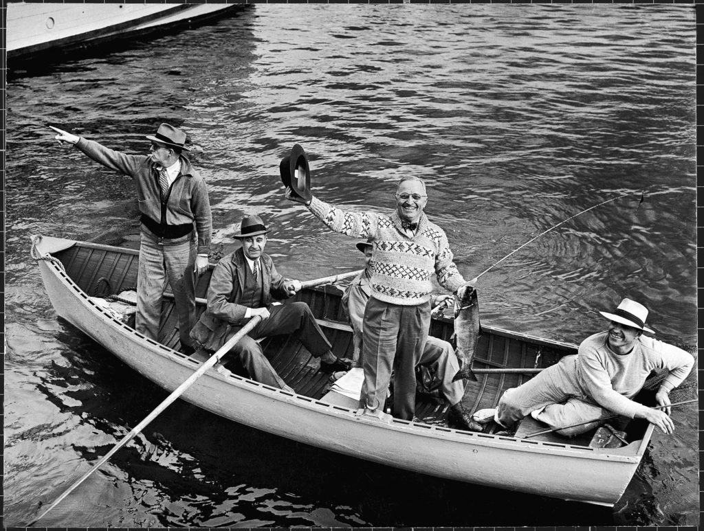 President Harry S. Truman waving his hat as he holds up a king salmon while fishing with others on Puget Sound. (Photo by George Skadding/The LIFE Picture Collection © Meredith Corporation)
