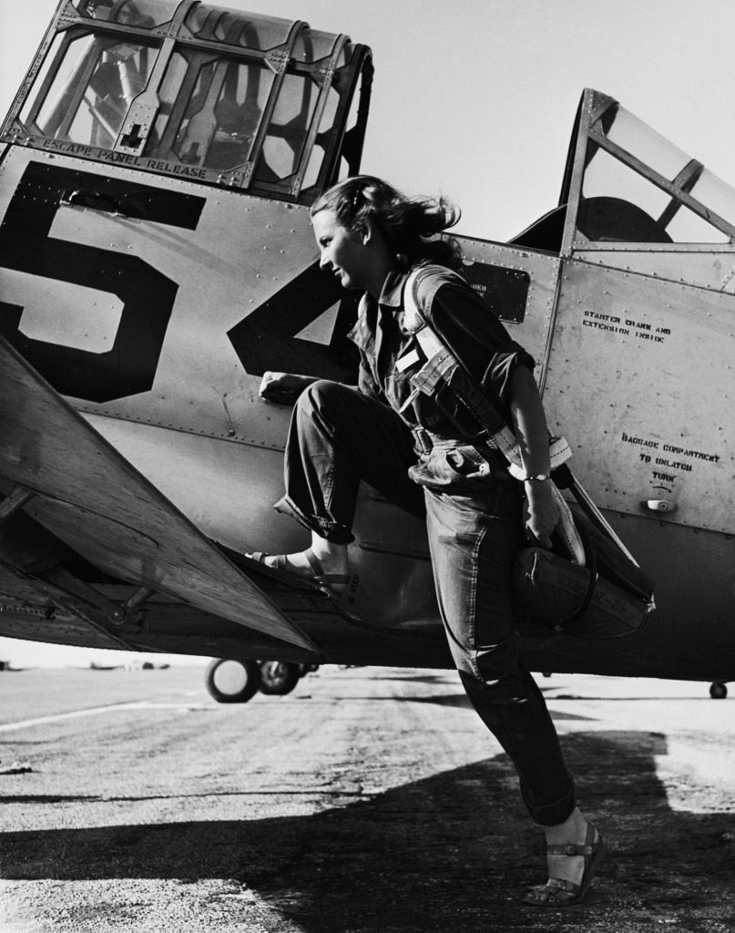Female pilot of the US Women's Air Force Service posed with her leg up on the wing of an airplane. (Photo by Peter Stackpole/The LIFE Picture Collection © Meredith Corporation)