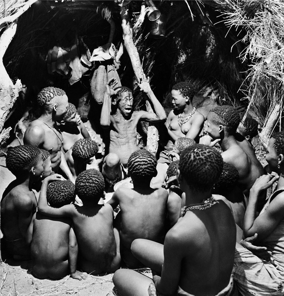 Bushman children sitting around their chief as he acts out a story, southern Kalahari Desert in central-southern Africa. (Photo by N.R. Farbman/The LIFE Picture Collection © Meredith Corporation)