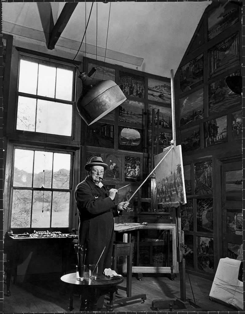 Former Prime Minister Winston Churchill smoking a cigar as he stands in his studio painting a landscape. (Photo by Hans Wild/The LIFE Picture Collection © Meredith Corporation)